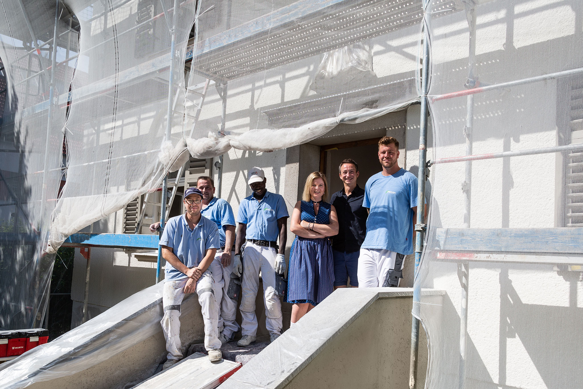 Maike Knauth mit Bauarbeitern vor dem frisch renovierten Pfarrhof